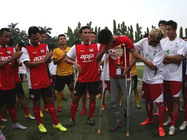 Alfin Tuasalamony menangis haru saat menyampaikan ucapan terima kasih atas dukungan rekan-rekan pesepakbola dalam Trofeo Charity Match yang diselenggarakan di Lapangan Simprug. Minggu (28/6). (Bola.com/Arief Bagus)