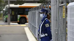 Penjaga mengenakan masker untuk mencegah penyebaran virus corona berdiri di lokasi pembangunan desa atlet yang akan digunakan selama Olimpiade dan Paralimpiade Tokyo 2020 di Tokyo (31/5/2021). Jepang mengkonfirmasi lebih dari 260 kasus virus corona baru pada hari Senin. (AP Photo/Eugene Hoshiko)