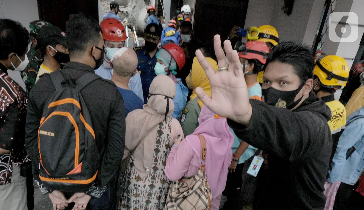 Petugas melarang wartawan mengambil gambar saat evakuasi anak berusia 12 tahun yang tertimpa beton akibat tergulingnya truk crane di Jalan Mawar, Perumnas Depok Jaya, Depok, Jawa Barat, Jumat (15/10/2021). (merdeka.com/Arie Basuki)