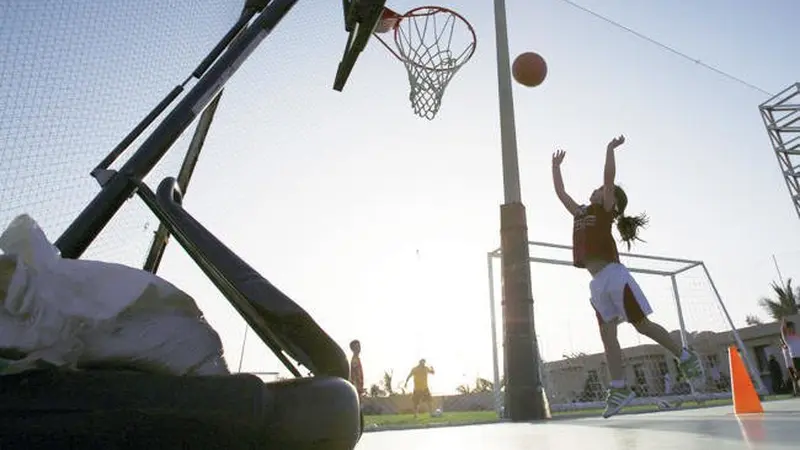 Seorang perempuan bermain basket di lapangan olahraga pribadi. (AP)