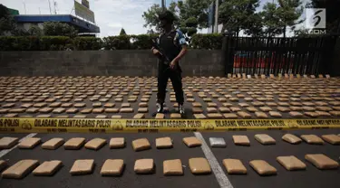 Petugas berjaga saat rilis barang bukti ganja sebanyak 1.300 paket dengan total 1,3 ton di Polres Jakarta Barat, Kamis (4/1). Polres Metro Jakbar berhasil menghentikan penyelundupan 1,3 ton ganja dari Provinsi Aceh ke Jakarta. (Liputan6.com/Arya Manggala)