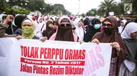Peserta aksi wanita membentangkan spanduk saat berunjuk rasa di Pintu Barat Monas, Jakarta, Selasa (18/7). (Liputan6.com/Faizal Fanani)