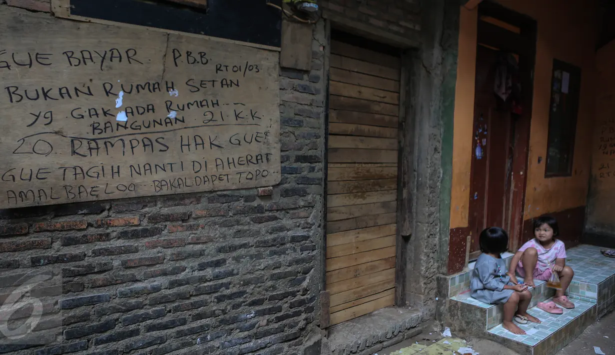 Tulisan protes terhadap penggusuran ditulis di tembok rumah warga di kawasan pemukiman Kampung Pulo, Jakarta Timur, Kamis (23/7). Pemerintah Provinsi DKI Jakarta akan menertibkan bangunan liar yang ada di wilayah Kampung Pulo. (Liputan6.com/Faizal Fanani)