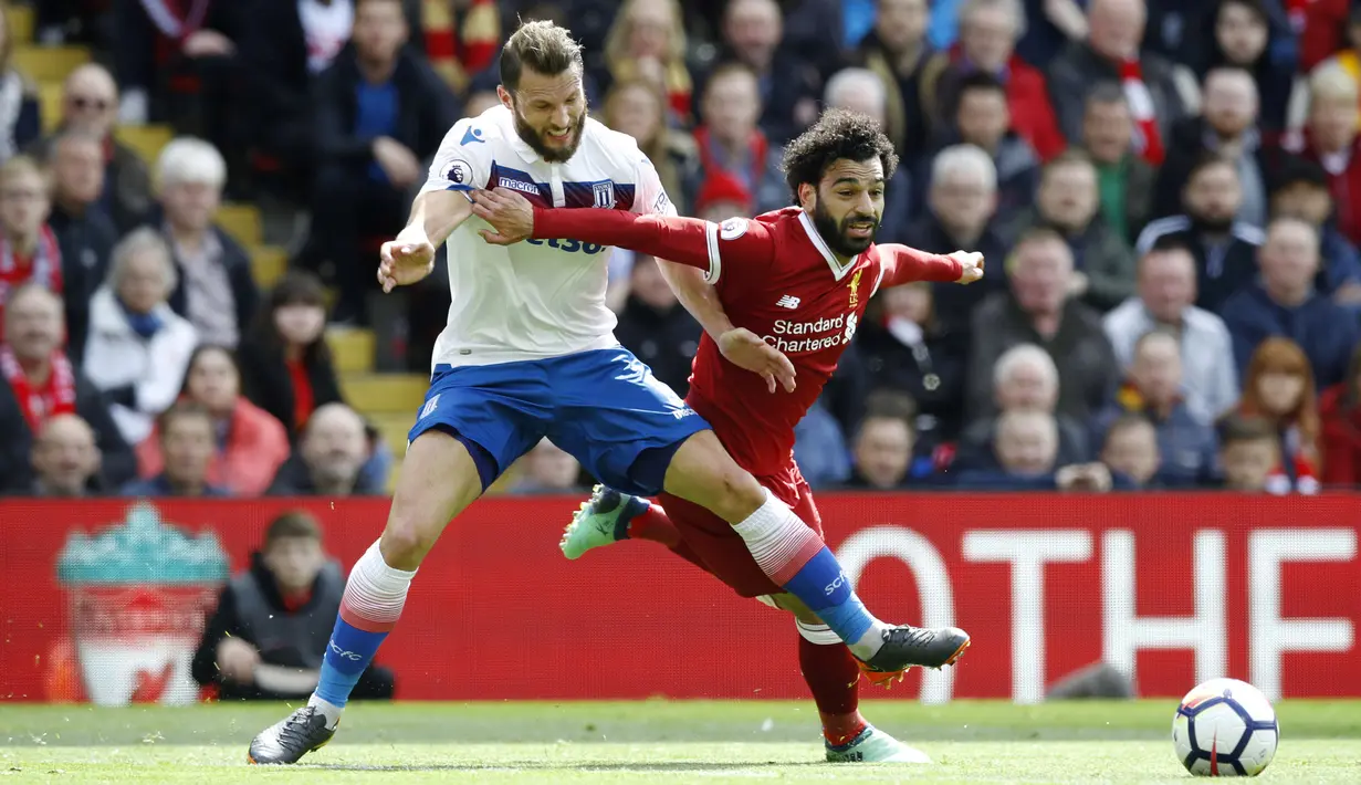 Pemain Stoke City, Erik Pieters (kiri) berusaha menahan laju pemain Liverpool, Mohamed Salah pada lanjutan Premier League di Anfield, Liverpool, (28/4/2018). Liverpool hanya bermain imbang 0-0 melawan Stoke City. (Martin Rickett/PA via AP)