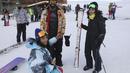 Pemain ski beristirahat di dasar lereng di resor ski Tochal tepat di luar ibu kota Teheran, Iran (1/1/2022). Di tengah polusi udara dan kesengsaraan ekonomi, penduduk Teheran menemukan kenyamanan di resor ski di utara Teheran di pegunungan Alborz. (AP Photo/Vahid Salemi)