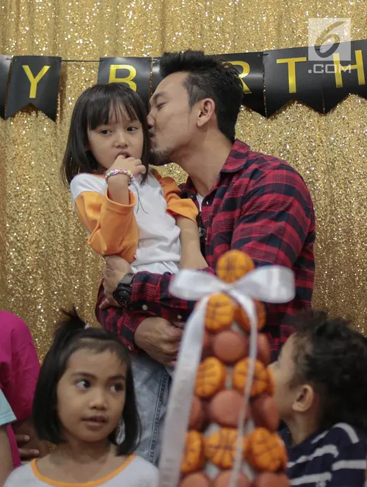 Aktor Denny Sumargo mencium seorang anak saat merayakan ulang tahunnya yang ke-37 di Panti Asuhan Dorkas, Jakarta, Kamis (11/10). (Liputan6.com/Faizal Fanani)