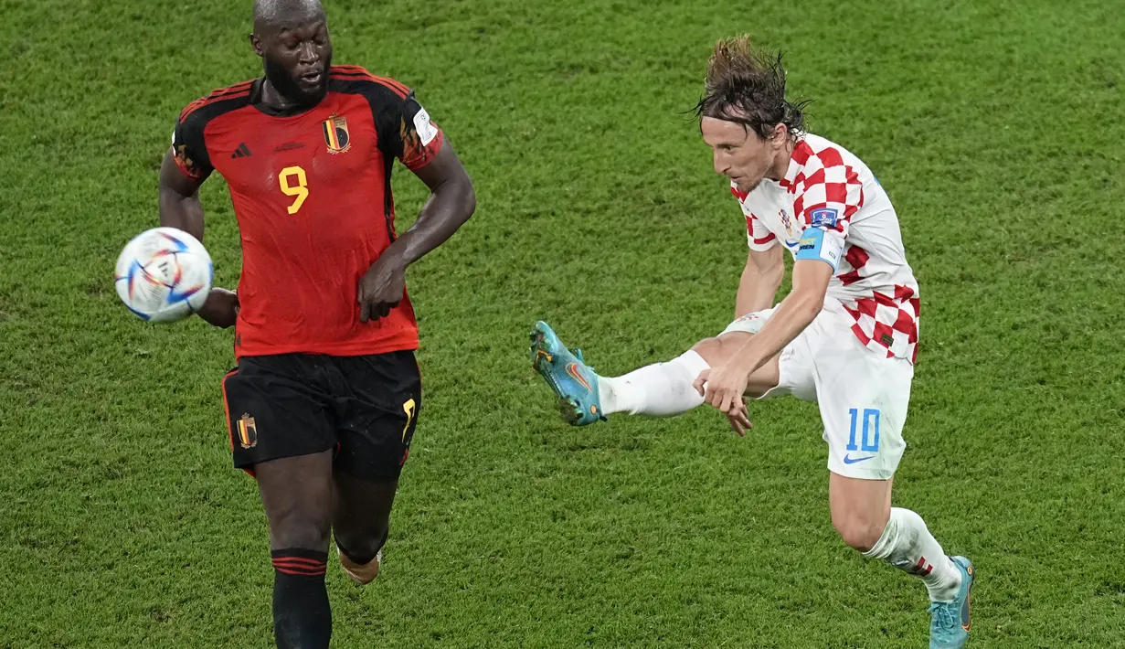 Gelandang Kroasia, Luka Modric mengumpan bola dari kawalan penyerang Belgia, Romelu Lukaku selama pertandingan grup F Piala Dunia 2022 di Stadion Ahmad Bin Ali di Al Rayyan, Qatar, Kamis (1/12/2022). Kroasia bermain imbang dengan Belgia dengan skor 0-0. (AP Photo/Ebrahim Noroozi)