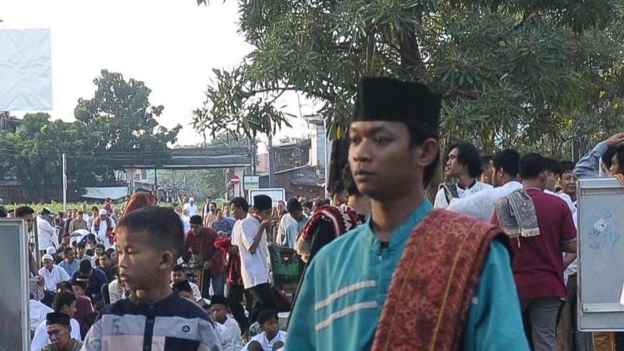 Jemaah yang baru datang terlihat membawa koran yang akan digunakan sebagai alas untuk salat Idulfitri. Foto: merdeka.com / Imam Buhori