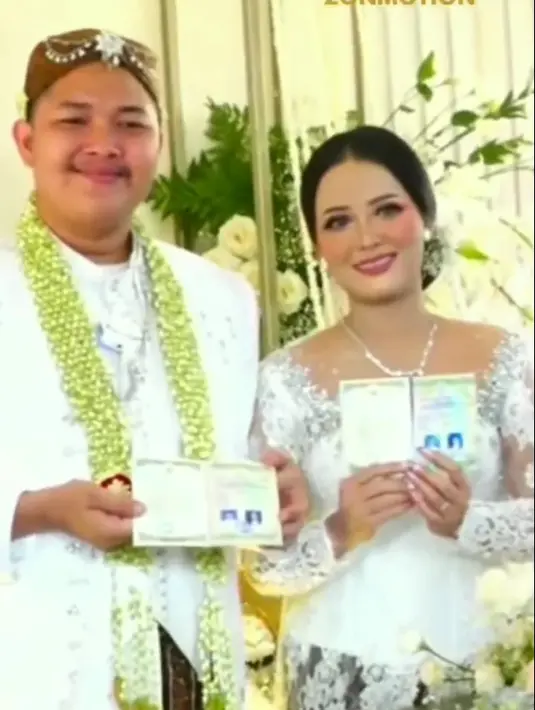 Nopek dan Yulia tampak serasi dengan busana pengantin warna putih yang dikenakan. Ronce bunga melati melingkat di leher Nopek. Penampilannya makin lengkap dengan blankon di kepala. [Instagram/dangdutmusikindonesia97]