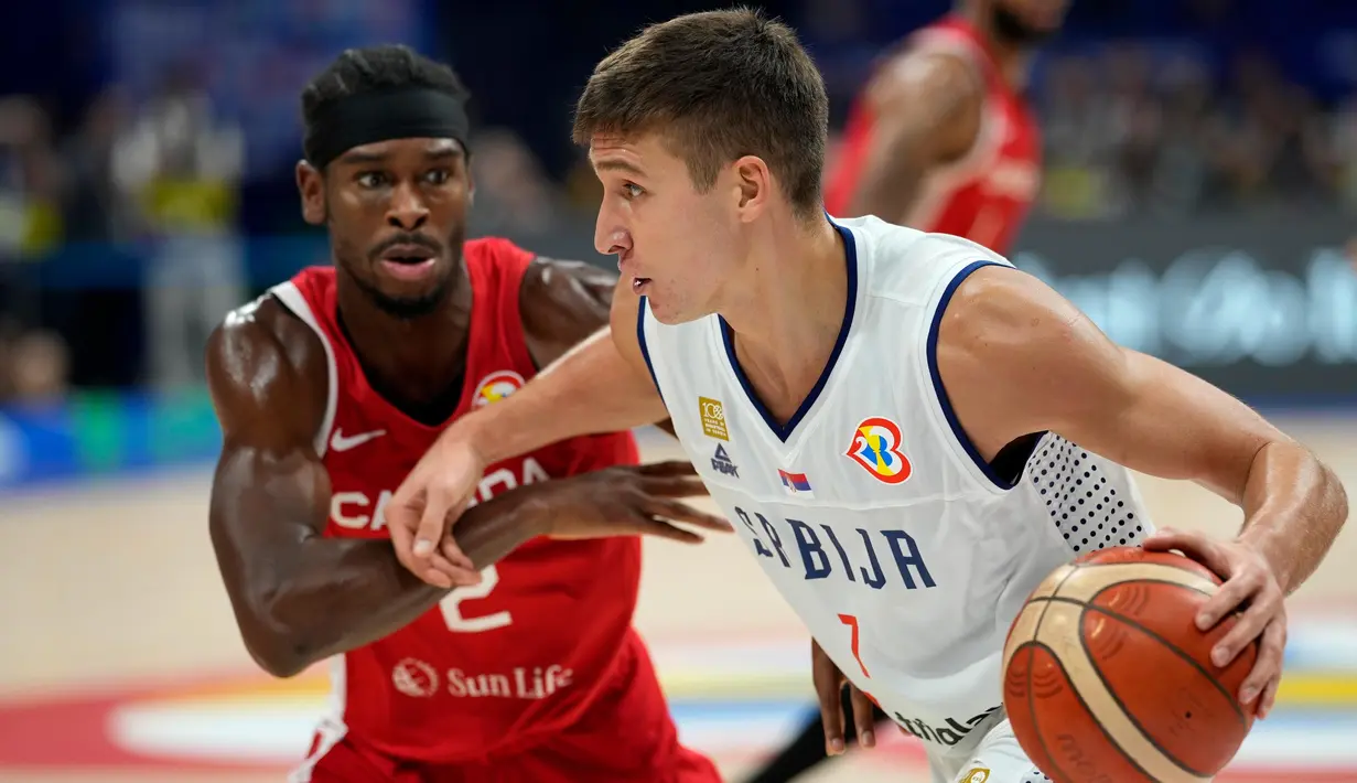 Pebasket timnas Serbia, Bogdan Bogdanovic (kanan) berusaha melewati pemain Kanada, Shai Gilgeous-Alexander dalam pertandingan semifinal Piala Dunia Basket di Manila, Filipina, Jumat, 8 September 2023. (AP Photo/Aaron Favila)