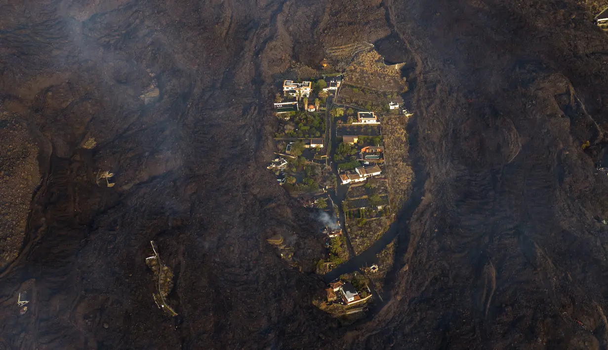 Lava gunung berapi Cumbre Vieja yang meletus mengalir di Pulau Canary La Palma, Spanyol, 28 Oktober 2021. Gunung berapi Cumbre Vieja yang terus meletus mengeluarkan sejumlah besar magma, gas dan abu. (AP Photo/Emilio Morenatti)