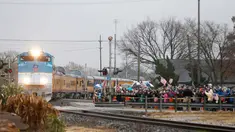 Warga memberi penghormatan saat kereta pembawa peti jenazah Presiden ke-41 AS George HW Bush di Navasota, Texas, Kamis (6/12). Jenazah mantan presiden AS George HW Bush dibawa menggunakan kereta pemakaman khusus. (AP Photo/Gerald Herbert)