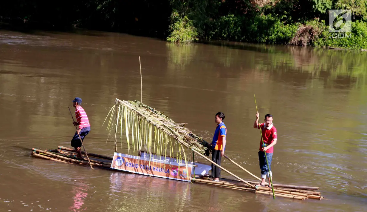 Peserta mengayuh rakit tradisional selama mengikuti kegiatan menyusuri sungai Bone, Gorontalo, Sabtu (23/3). Pemerintah Daerah Kabupaten Bone Bolango (Bonebol), Gorontalo meyelenggarakan iven tahunan yakni menyusuri sungai Bone dengan mengunakan rakit tradisional. (Liputan6.com/Arfandi Ibrahim)