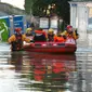 Petugas mengevakuasi warga yang terjebak banjir dirumahnya di Tadcaster, Inggris utara, Minggu (27/12). Banjir akibat luapan sungai Ouse yang telah memperburuk sejumlah wilayah Inggris utara. (REUTERS/Andrew Yates)