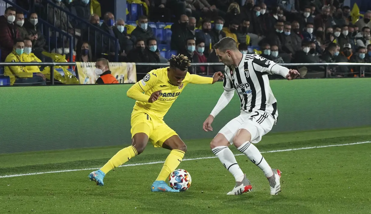 Penyerang Villarreal, Samuel Chukwueze berusaha melewati bek Juventus, Mattia De Scigli pada pertandingan leg pertama Liga Champions di Estadio de la Ceramica, Spanyol, Rabu (23/2/2022).  Juventus bermain imbang atas Villarreal 1-1.  (AP Photo/Alberto Saiz)
