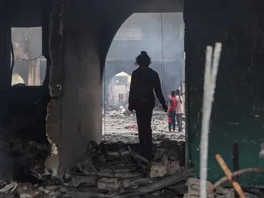 Seorang gadis Palestina memeriksa kerusakan setelah serangan Israel terhadap gedung sekolah Yafa, di Kota Gaza pada 23 April 2025. (Omar AL-QATTAA/AFP)