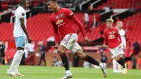 Pemain Manchester United, Mason Greenwood, berselebrasi setelah membobol jala West Ham United pada laga Premier League di Old Trafford, Kamis (23/7/2020) dini hari WIB. (Catherine Ivill/ POOL / AFP)