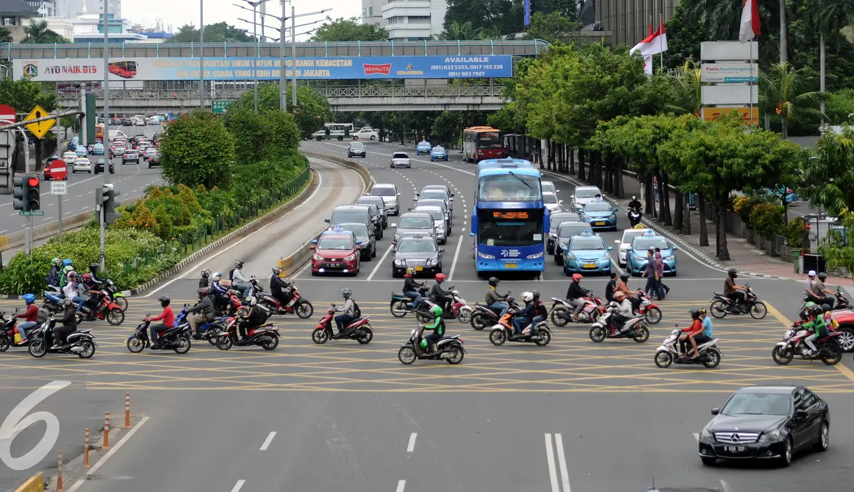 Suasana arus lalu lintas di perempatan Sarinah Jalan MH Thamrin Jakarta, Jumat (25/11). Dibayangi aksi massa besar-besaran pada Jumat (25/11) arus lalu lintas sejumlah ruas jalan protokol di Jakarta terlihat normal. (Liputan6.com/Helmi Fithriansyah)