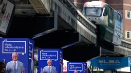 Sebuah monorail melintas di atas iklan elektronik dengan wajah PM Malaysia Najib Razak, Kuala Lumpur, Malaysia, Senin (7/5). Najib Razak akan bersaing dengan mantan PM Malaysia Mahathir Mohamad. (AP Photo/Andy Wong)