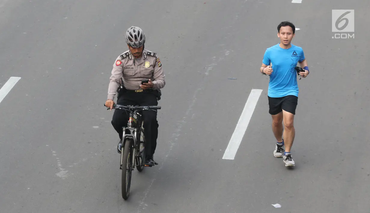 Aparat polisi bersepeda mengamankan Parade Asian Games 2018 di Jalan Thamrin, Jakarta, Minggu (13/5). Sejumlah pejabat negara hadir seperti Wakil Presiden RI Jusuf Kalla dan Gubernur DKI Anies Baswedan.  (Liputan6.com/Arya Manggala)