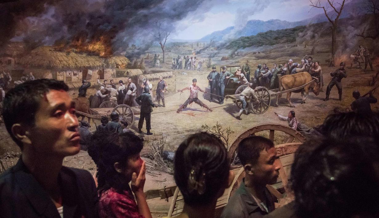 Pengunjung melihat lukisan tentara AS menyiksa seorang pria Korea Utara di Sinchon Museum of American War Atrocities di Pyongyang 24 Juli 2017. Pada Juli 2015, museum ini dibangun ulang dan dipindahkan ke sebuah lokasi baru. (AFP Photo/Ed Jones)