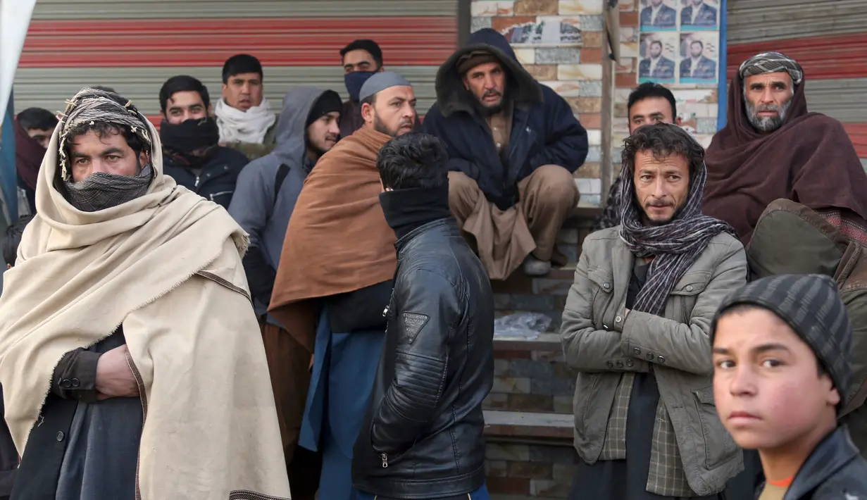 Warga Afghanistan melihat lokasi serangan bom mobil Taliban di Kabul, Afghanistan (15/1). Empat orang tewas dan 113 orang lainnya terluka akibat ledakan yang terjadi di dekat kompleks asing tersebut. (AP Photo/Rahmat Gul)