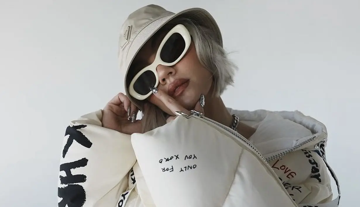 Kali ini, ia tampil serba putih dengan padding jaket dan rambut pendek bob warna abu-abu dipadukan bucket hat dan kacamata warna serupa.@agnezmo
