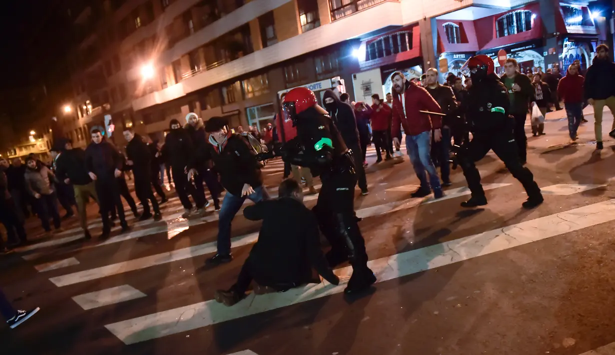 Polisi bentrok dengan suporter Athletic Bilbao dan Spartak Moskow di Stadion San Mames, Bilbao, Spanyol, Kamis (22/2). Seorang polisi tewas setelah mencoba membubarkan bentrok suporter Athletic Bilbao dan Spartak Moskow. (AP Photo/Alvaro Barrientos)