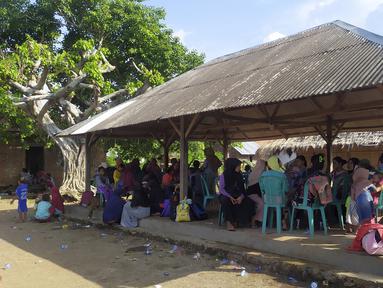 Orang-orang menunggu di tempat penampungan sementara setelah gempa bumi di Adonara, Indonesia, Selasa (14/12/2021). BMKG mencabut peringatan dini tsunami usai gempa gempa berkekuatan magnitudo 7,3 yang mengguncang Larantuka, Nusa Tenggara Timur (NTT). (AP Photo)