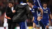 Manajer Chelsea, Antonio Conte (kiri) melakukan selebrasi bersama anak asuhnya usai pertandingan kontra Stoke City, di Bet365 Stadium, Stoke-on-Trent (18/3/2017). Conte mengaku melakukan perjudian terkait formasi pemain.  (AFP/Oli Scarff)