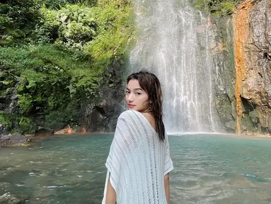 Menikmati momen seru liburan ke curug yang ada di Kawasan Gunung Salak Bogor, Glenca Chysara tampil menawan ketika mengabadikan potretnya di depan air terjun. Melihat suasana di curug yang menyegarkan, tentu siapa saja ingin berendam di airnya yang terlihat bening. (Liputan6.com/IG/@glencachysaraofficial)