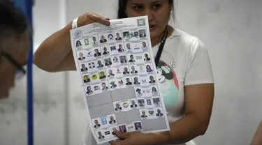 Seorang petugas pemilu menunjukkan surat suara saat penghitungan suara dimulai setelah pemungutan suara ditutup selama pemilihan umum di Guatemala City, Minggu, 25 Juni 2023. (AP Photo/Moises Castillo)