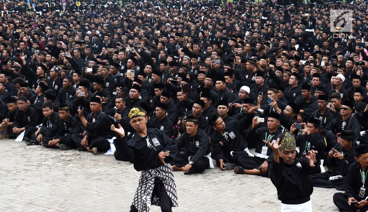 Dua pesilat memeragakan jurus saat kegiatan Bumi Reog Berzikir 2018 dan Deklarasi Pemilu Damai di Alun-alun Ponorogo, Jawa Timur, Minggu (30/12). Kegiatan yang diikuti 45.024 pesilat memecahkan Rekor MURI. (Liputan6.com/HO/Firdaus)