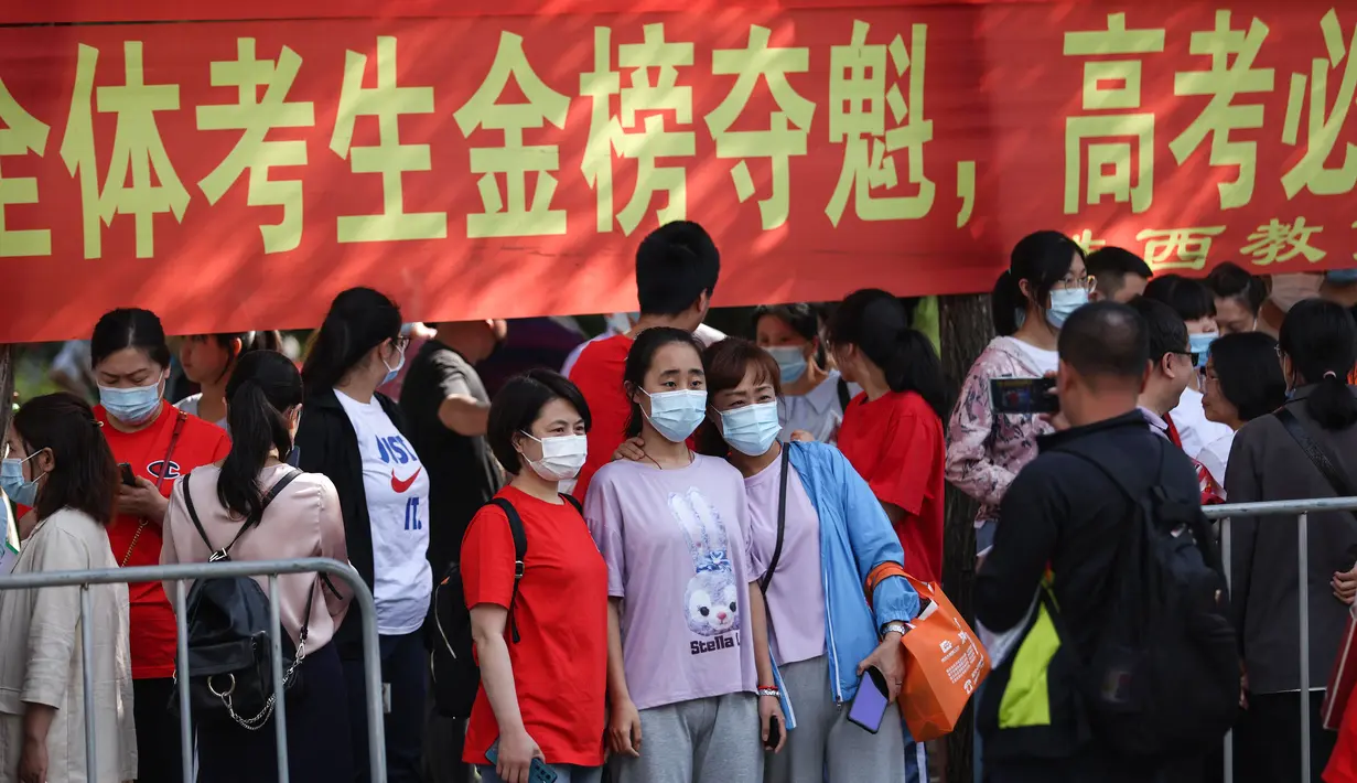 Siswa berpose untuk foto ketika mereka tiba di sekolah untuk mengikuti Ujian Masuk Perguruan Tinggi Nasional (NCEE), yang dikenal sebagai Gaokao, di Wuhan, di provinsi Hubei tengah China (7/6/2021). (AFP/STR)