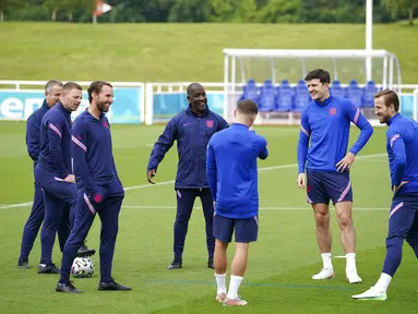 Pelatih Inggris, Gareth Southgate (ketiga kiri) berbicara dengan Harry Kane, Harry Maguire dan asisten Chris Powell selama sesi latihan di St George's Park, Inggris, Sabtu (10/7/2021). Inggris akan bertanding melawan Italia pada final Euro 2020 di Stadion Wembley. (AP Photo/Dave Thompson)