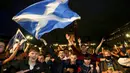 Suporter Skotlandia berkumpul dan merayakan hasil imbang melawan Inggris di Glasgow, Skotlandia, Jumat (18/6/2021). (Robert Perry/PA via AP)