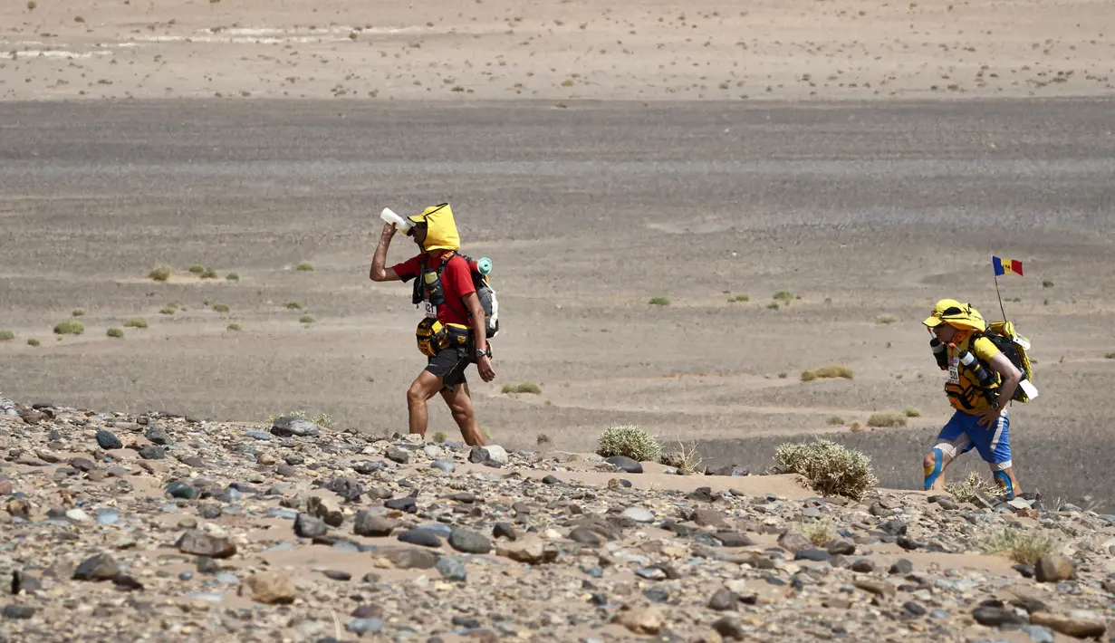 Peserta meminum air saat mengikuti kejuaraan Marathon des Sables ke-32 tahap ketiga di Gurun Sahara, selatan Maroko, Selasa (11/4). Salah satu kompetisi paling berat itu menjadi ajang tahunan sejak 1986 di setiap bulan April. (JEAN-PHILIPPE KSIAZEK/AFP)