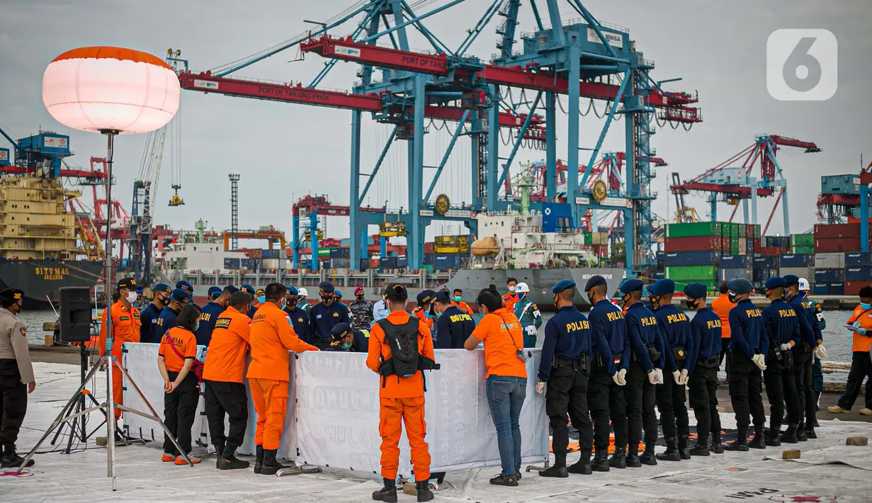 Petugas melihat body part dari kapal Basarnas di JICT II Tanjung Priok, Jakarta, Jumat (15/1/2021).  Badan SAR Nasional (Basarnas) kembali menerima paket kiriman hasil pencarian hari ketujuh. (Liputan.com/Faizal Fanani)