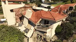 Tumpukan atap yang runtuh, dinding yang hancur, cerobong miring, dan geladak yang menggantung di atas ngarai yang berdekatan.  (Ted Soqui via AP)