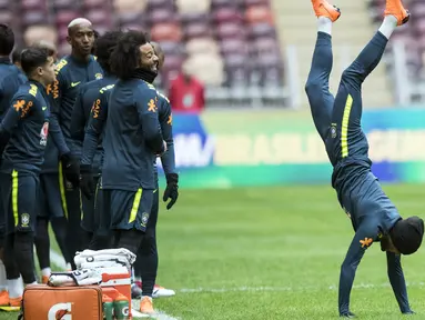 Aksi pemain Brasil, Dani Alves (kanan) saat berjalan dengan tangan pada sesi latihan di Stadion Olimpiyskiy Luzhniki, Moskva, Rusia, (22/3/2018). Brasil akan melawan Rusia pada laga uji coba 23 Maret. (AP/Pavel Golovkin)