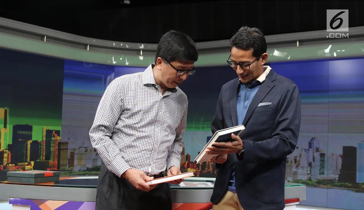 Calon wakil presiden Sandiaga Salahuddin Uno (kanan) memberikan cindera mata kepada Direktur Utama SCM Sutanto Hartono (kiri) saat berkunjung ke Kantor SCTV, Jakarta, Kamis (20/9). (Liputan6.com/Herman Zakharia)
