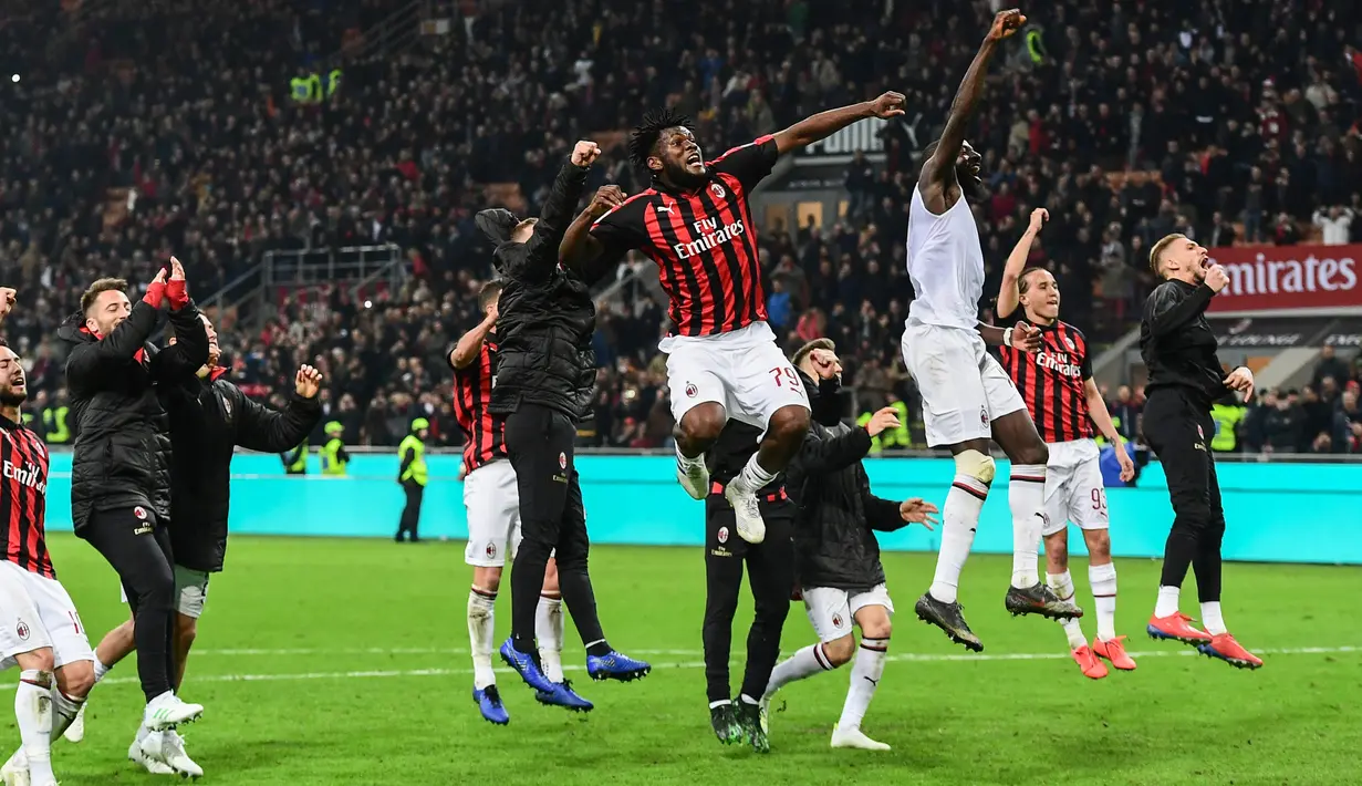 Gelandang AC Milan, Franck Kessie (tengah) dan rekan setimnya merayakan kemenangan bersama suporter usai pertandingan melawan Lazio pada lanjutan Liga Serie A Italia di stadion San Siro (13/4). Milan menang tipis 1-0 atas Lazio berkat gol penalti Kessie. (AFP Photo/Miguel Medina)