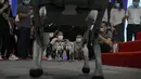 Anak-anak yang memakai masker wajah bermain dengan robot side-follow cerdas Unitree Go 1 selama Konferensi Robot Dunia di Pusat Konferensi dan Pameran Internasional Yichuang di Beijing, Kamis (18/8/2022). (AP Photo/Andy Wong)