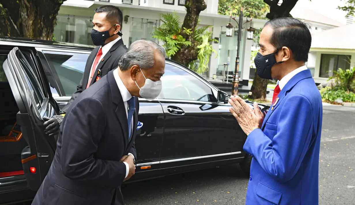 Presiden Indonesia Joko Widodo (kanan) menyapa Perdana Menteri Malaysia Muhyiddin Yassin saat bertemu di Istana Merdeka, Jakarta, Jumat (5/2/2021). Penyambutan dilakukan sesuai dengan protokol kesehatan pencegahan COVID-19. (Agus Suparto, Indonesian President Palace via AP)