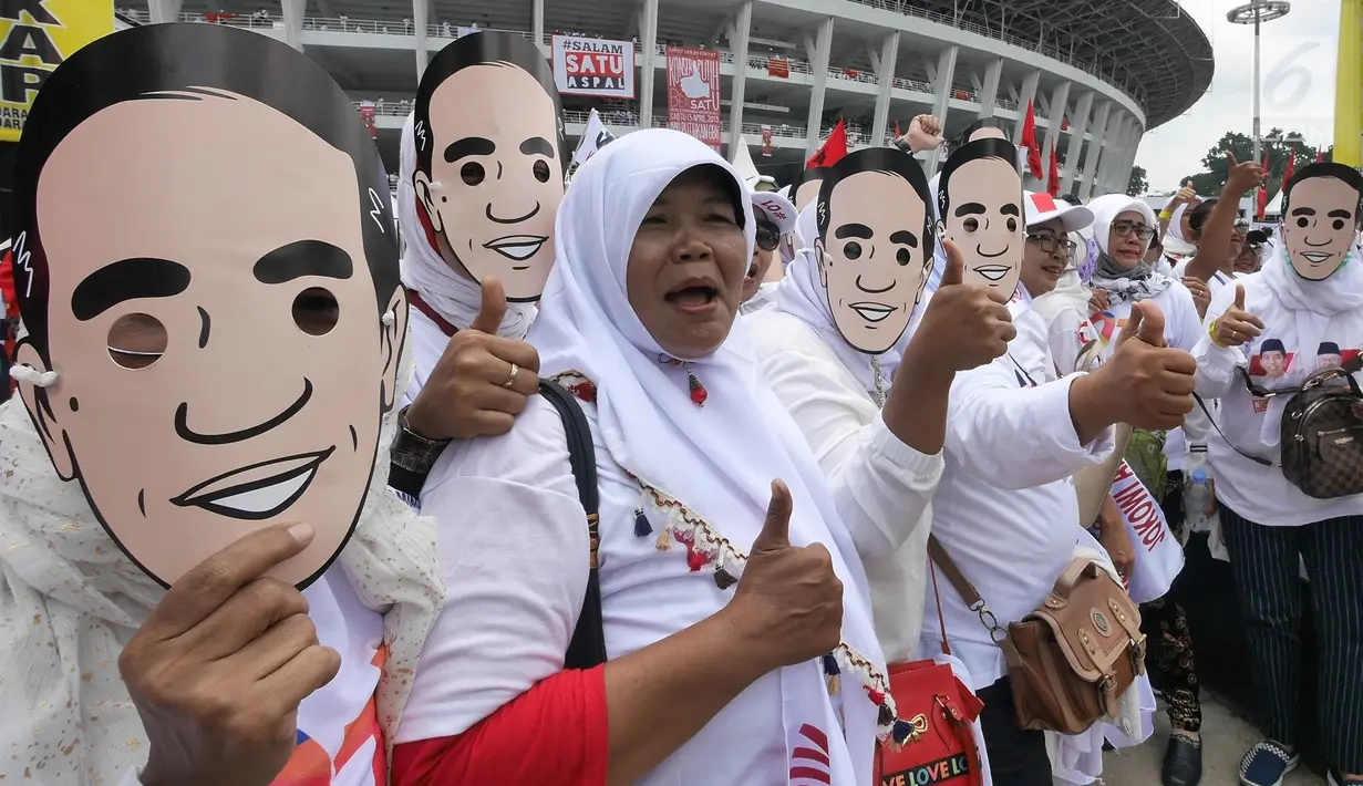 Pendukung capres dan cawapres Joko Widodo (Jokowi)-Ma'ruf Amin kenakan topeng Jokowi pada kampanye akbar di Stadion Utama GBK, Senayan, Jakarta, Sabtu (13/15). Kampanye yang diisi dengan konser musik dari ratusan selebritas bertajuk Konser Putih Bersatu. (Liputan6.com/Herman Zakharia)