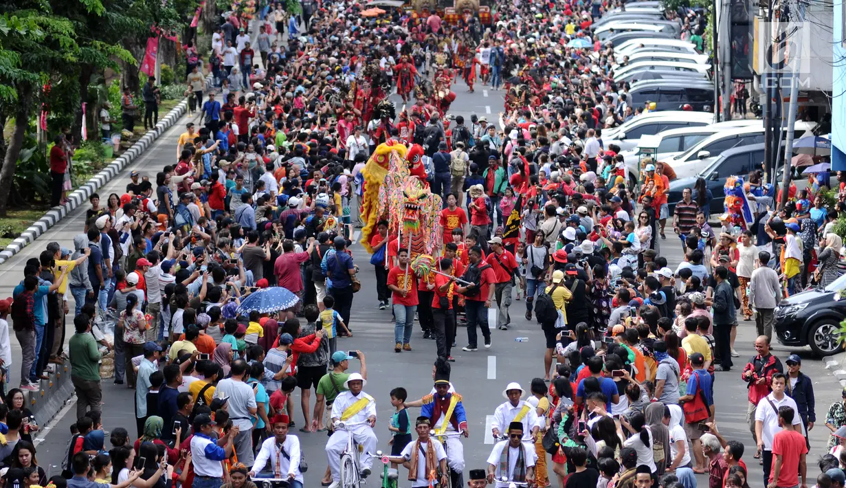 Atraksi liong menembus kerumunan warga di Jalan Gajah Mada, Jakarta, Minggu (4/3). Beragam atraksi budaya yang ada di Indonesia ditampilkan dalam karnaval perayaan Cap Go Meh 2018 di kawasan Glodok Jakarta. (Liputan6.com/Helmi Fithriansyah)