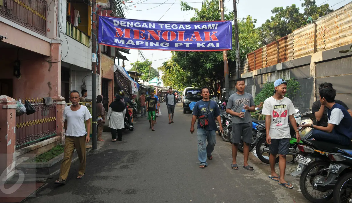 Warga memasang spanduk saat aksi penolakan pengosongan rumah aset kepemilikan PT KAI di Jalan Menara Air, Kelurahan Manggarai, Jakarta, Selasa (19/7). Warga menolak terhadap pengosongan rumah yang dilakukan oleh PT KAI. (Liputan6.com/Gempur M Surya)