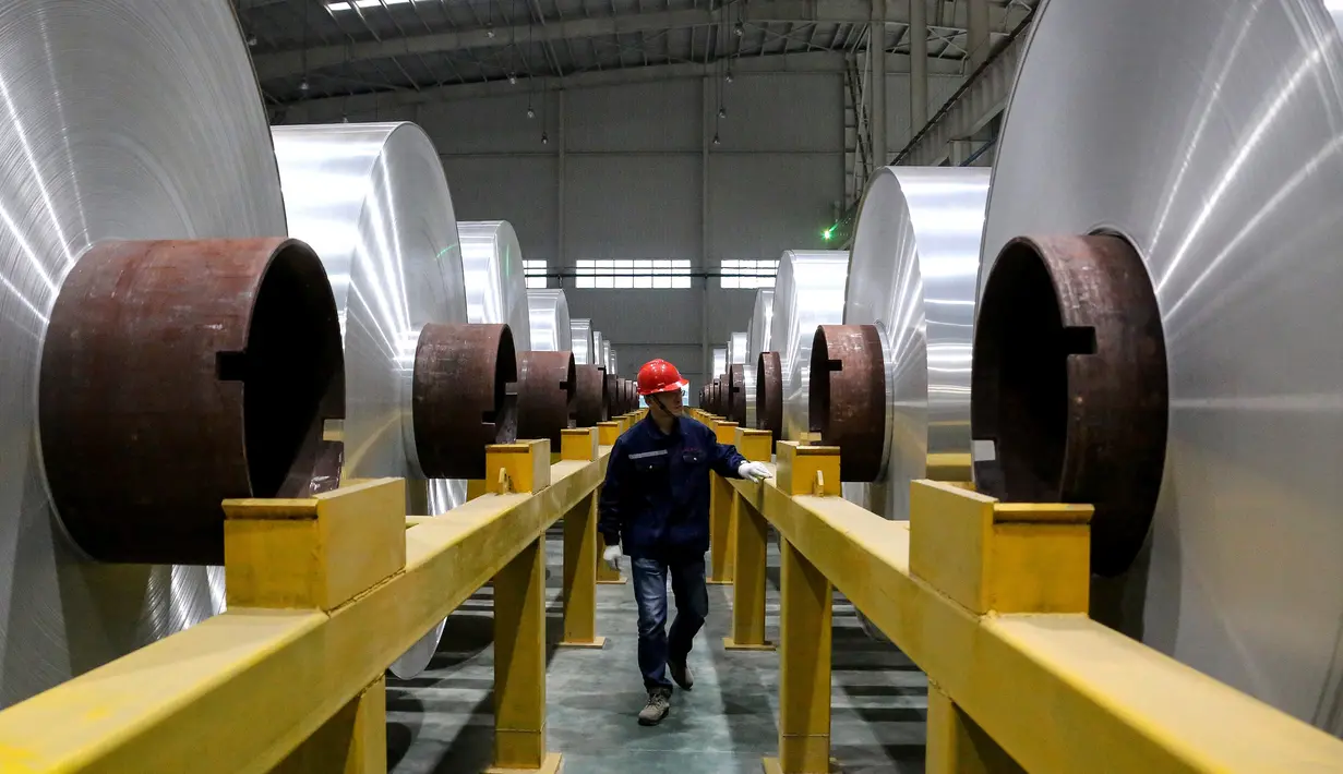 Pekerja memeriksa gulungan aluminium di sebuah pabrik di Zouping di provinsi Shandong bagian timur China (23/11/2019). Zouping adalah salah satu negara terkaya di negeri ini. Kemakmuran ekonominya bergantung pada pengembangan industri aluminium. (AFP Photo/STR)