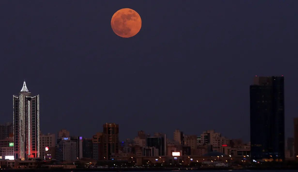 Bulan Purnama Stroberi atau Strawberry Full Moon muncul di atas Kota Kuwait, pada Kamis (24/6/2021). Strawberry Full Moon adalah istilah yang diambil dari hikayat atau cerita tradisi dari suku-suku asli Amerika. (YASSER AL-ZAYYAT / AFP)