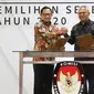 Mendagri, Tito Karnavian (kiri) dan Ketua KPU Arief Budiman saat Serah Terima Data Penduduk Potensial Pemilih Pemilihan (DP4) untuk Pemilihan Serentak 2020 di Jakarta, Kamis (23/1/2020). Kemendagri menyerahkan DP4 dengan jumlah 105 juta. (Liputan6.com/Herman Zakharia)